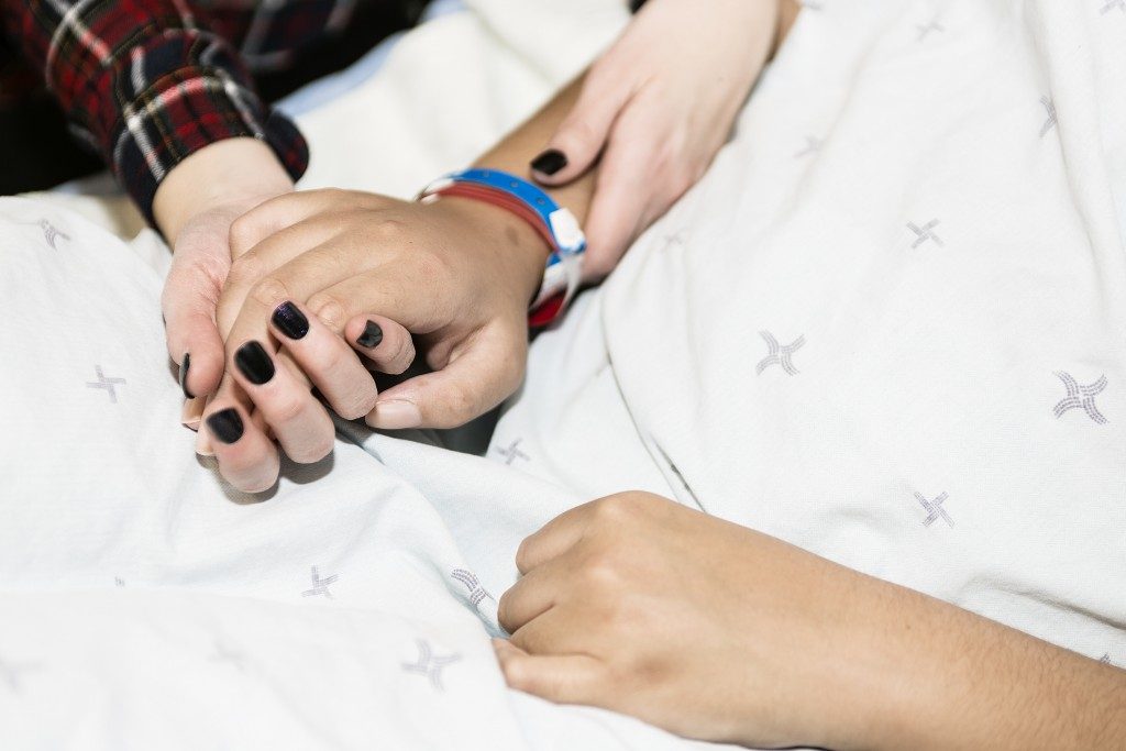 Holding hands of a patient and loved one