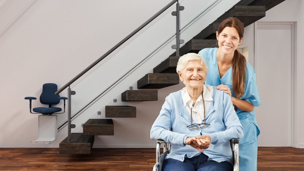 Senior and caretaker posing with stair lift behind