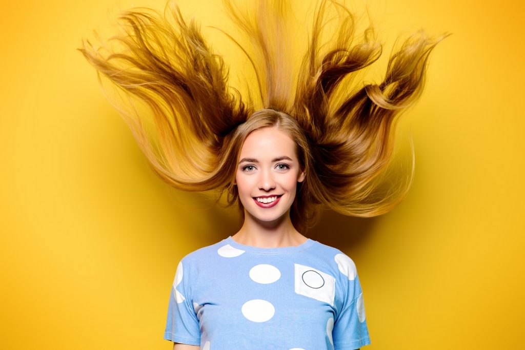 Woman with healthy hair in yellow background