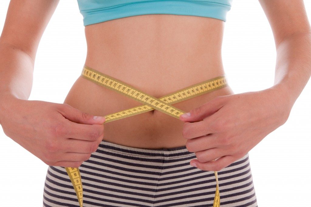 Woman measuring her waist