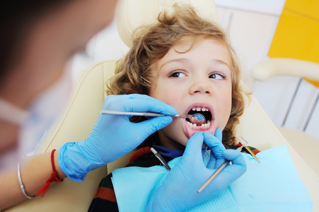 dentist checking cavities on a child's teeth