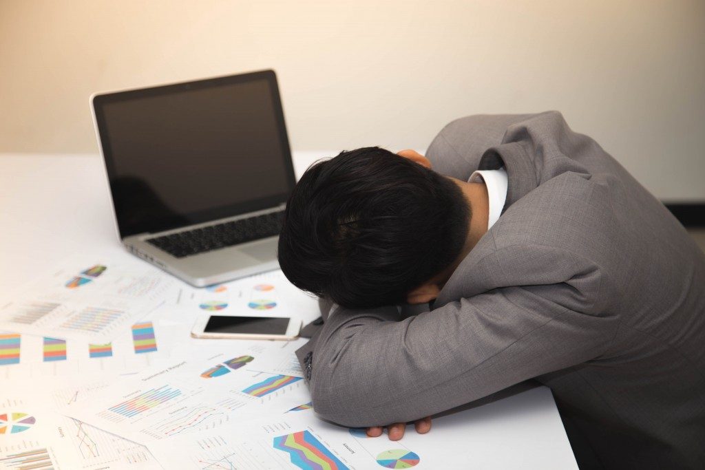 fatigued businessman asleep on his desk