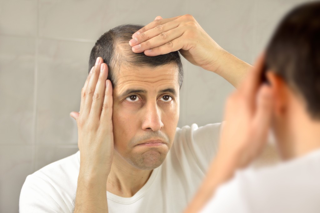 Man checking hair at the mirror
