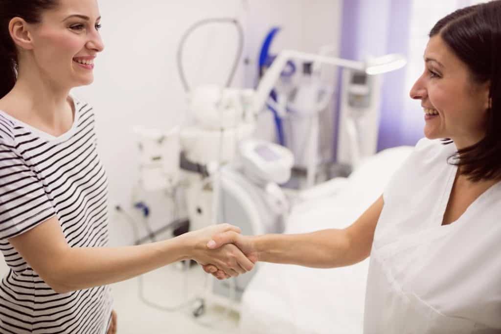 Doctor shaking hands with patient at clinic