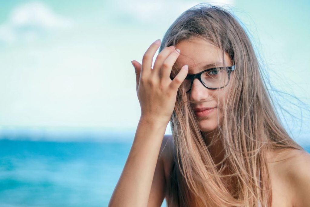 woman wearing black framed eyeglasses in white top