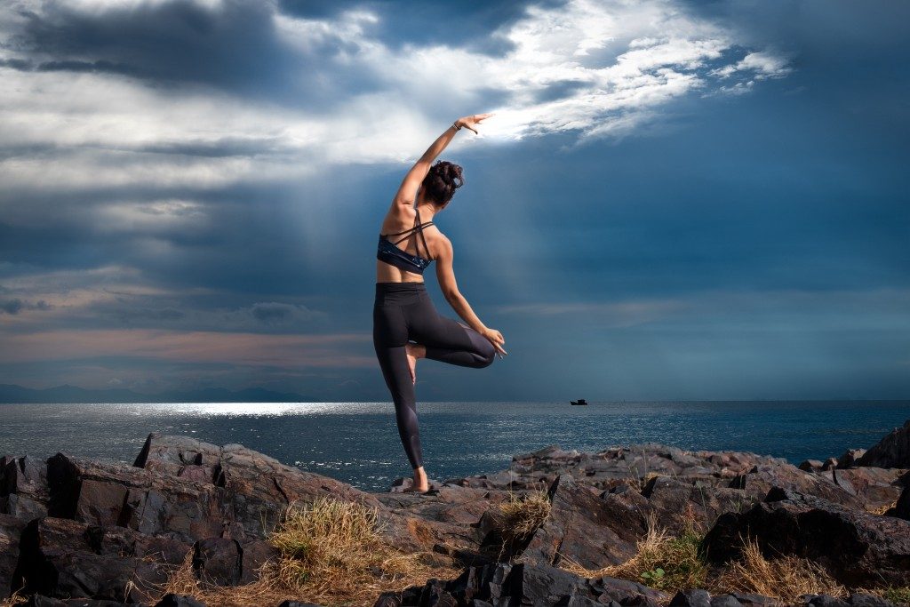 Woman doing yoga on a hill
