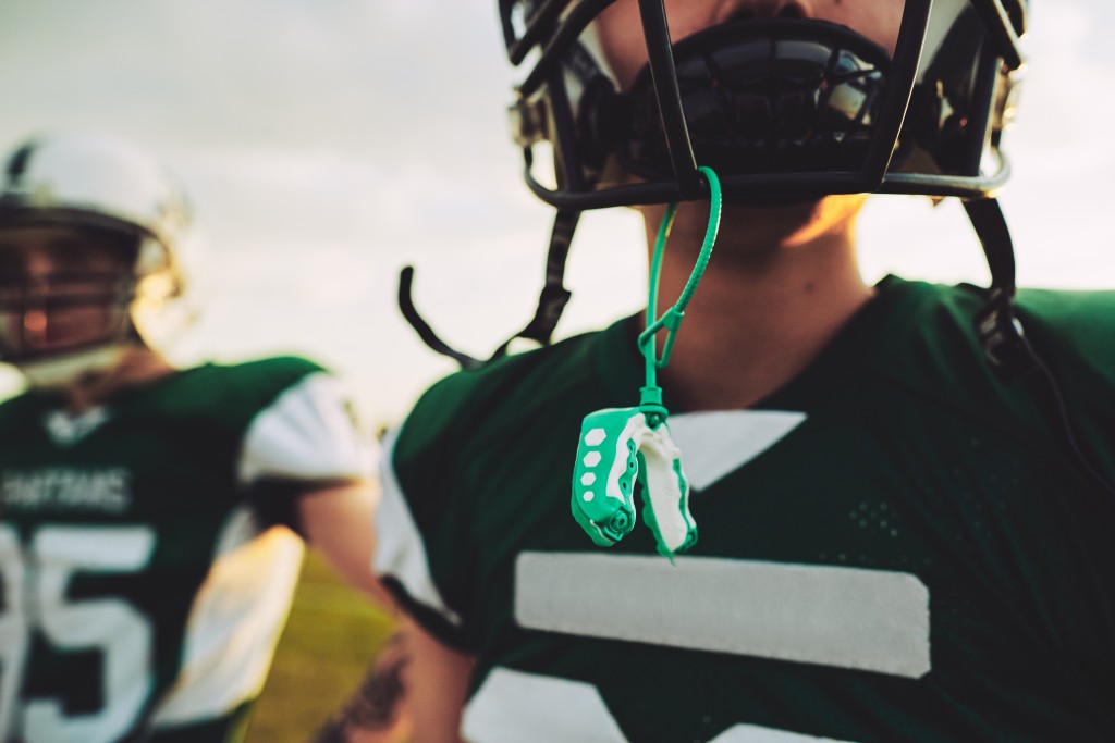 American football player with his mouthguard hanging
