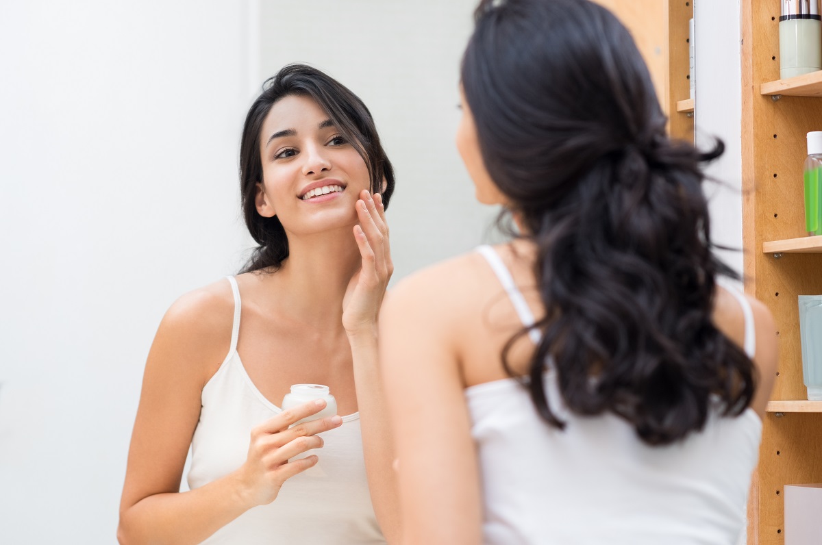 girl apllying cream on her face