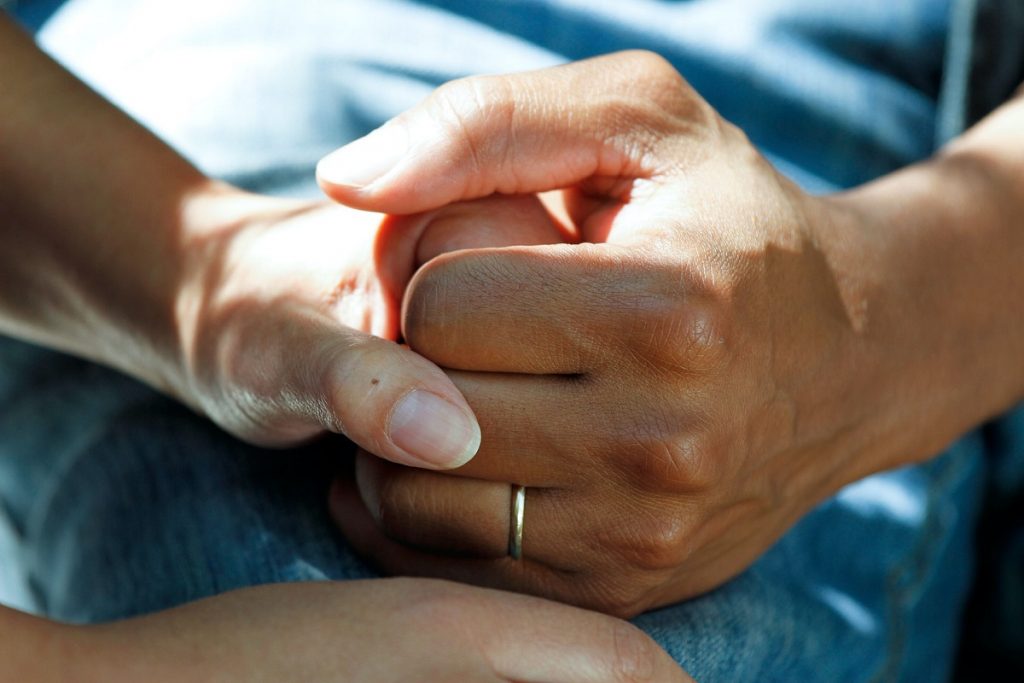 person wearing a ring holding hand