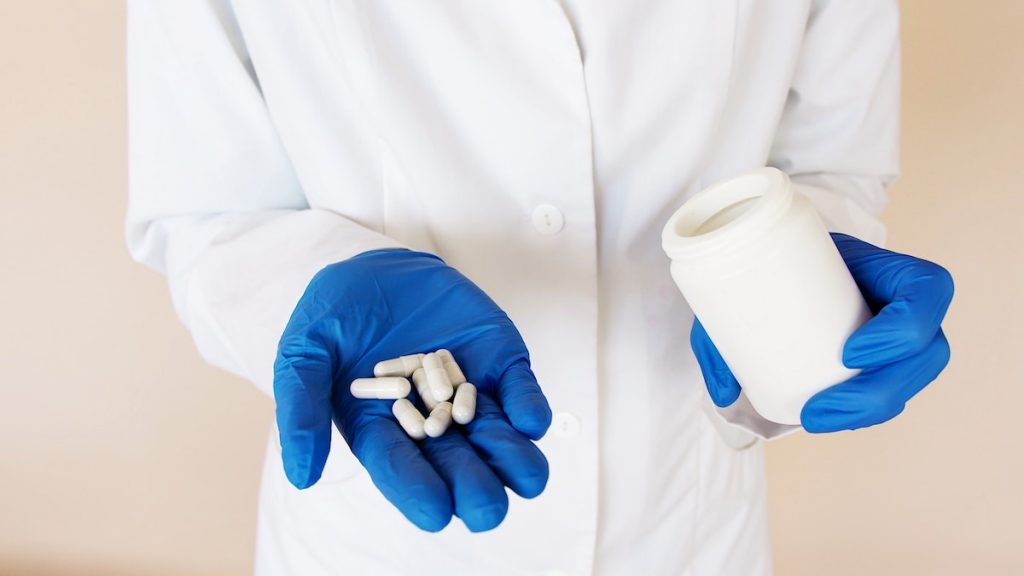 pharmacist holding pill capsules