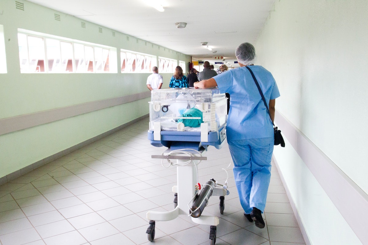 healthcare worker wheeling in a baby