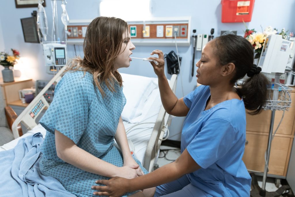 nurse checking patient's throat