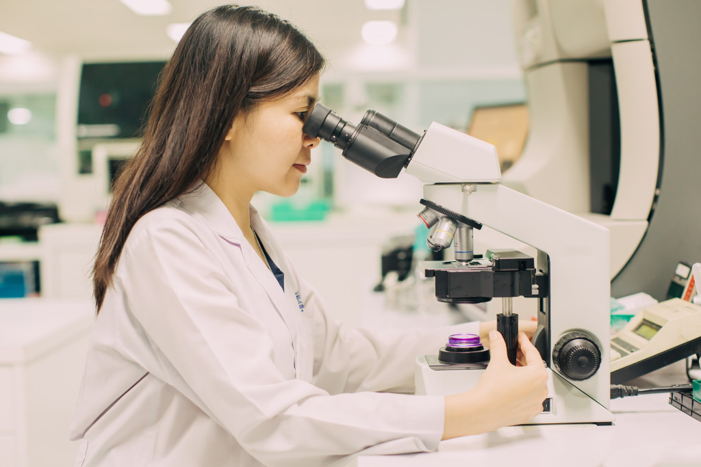 a female medical staff using microscope to check laboratory test