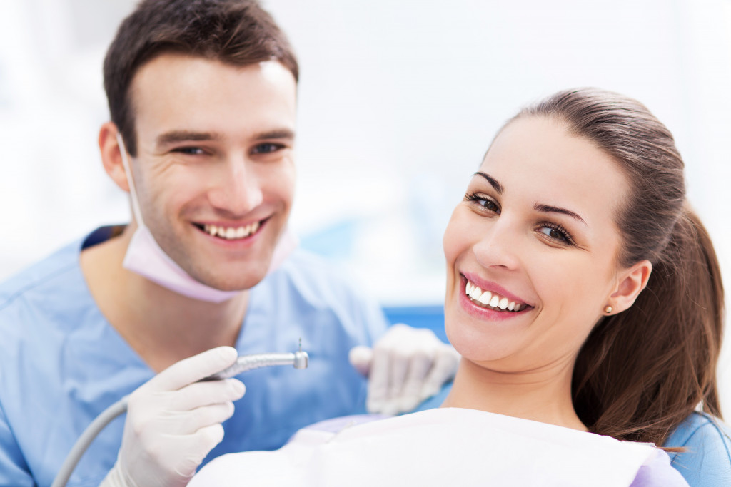 a patient and dentist smiling during a dental cleaning