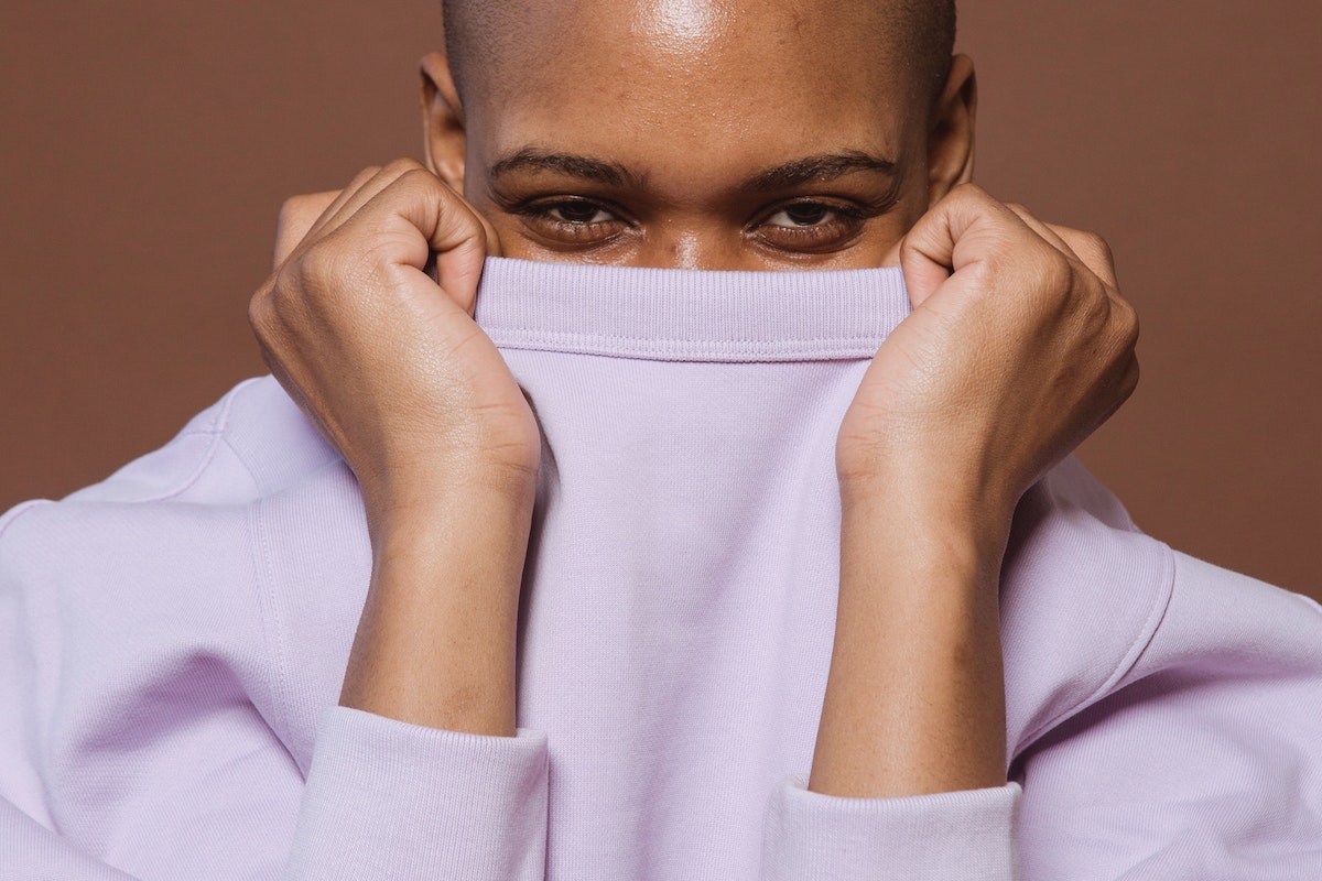 African American lady covering face with shirt collar