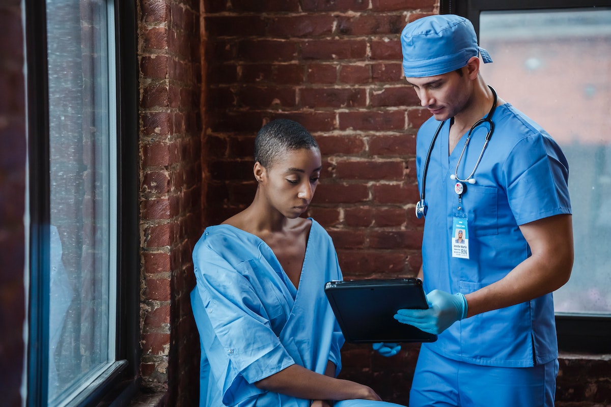 medical service worker shows a tablet to a patient