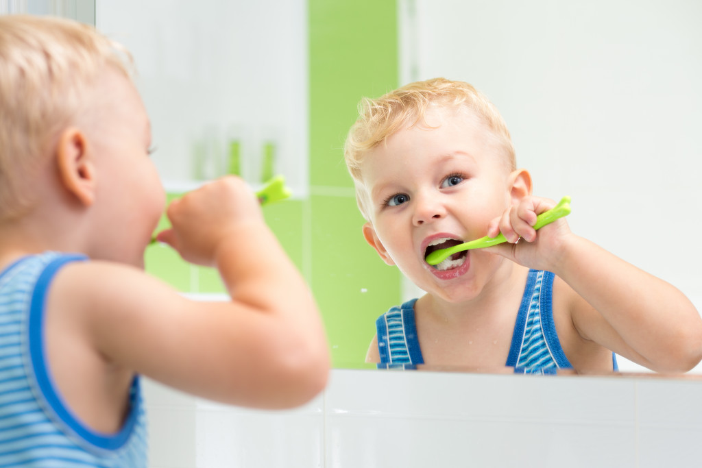 a blonde kid brushing his teeth