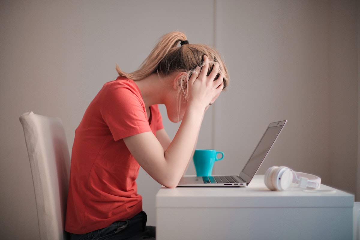 stressed woman while working on her laptop