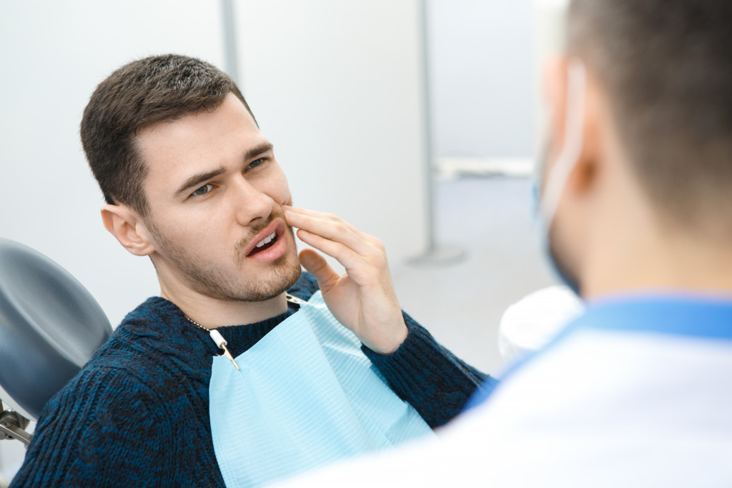 man in clinic with hurting teeth