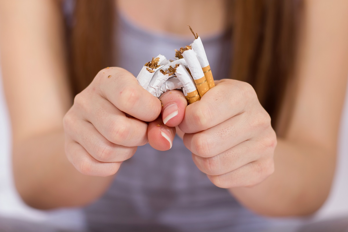 woman breaking bunch of cigarettes