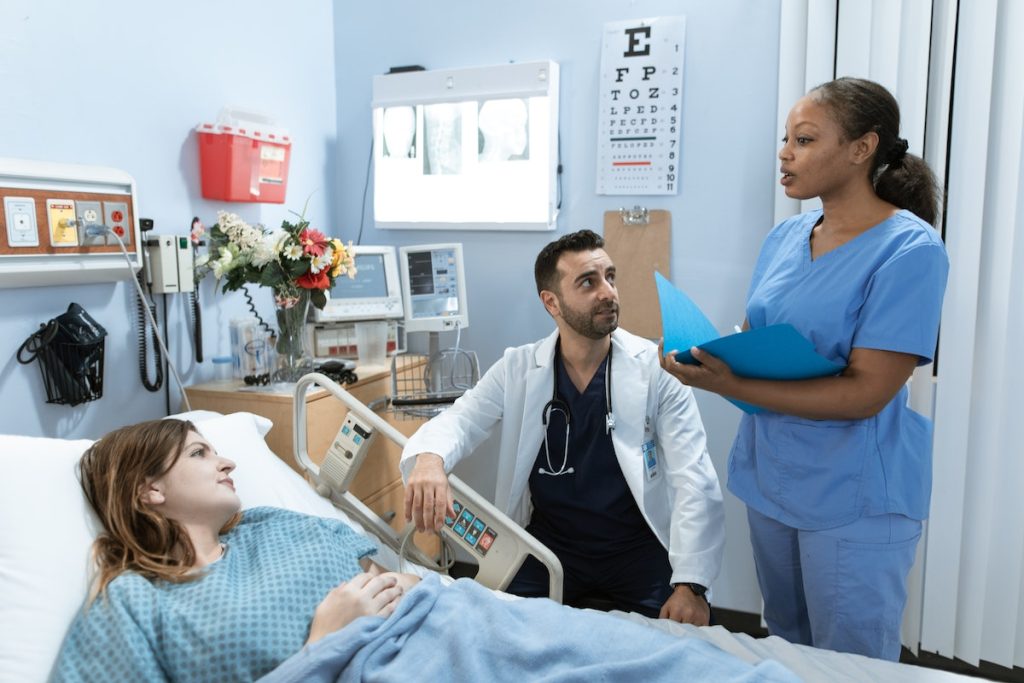 nurse talking to patient in bed