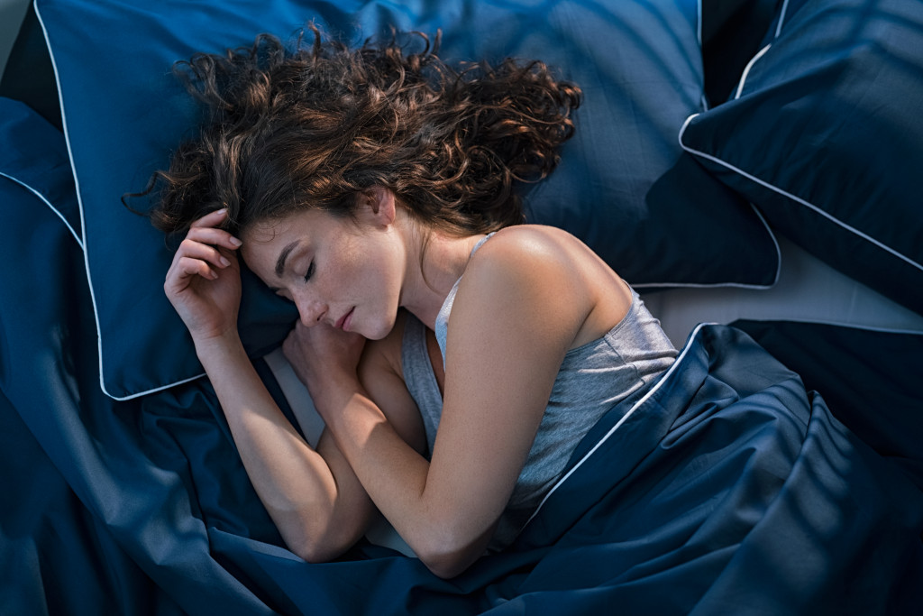 woman in beauty sleep in blue bed