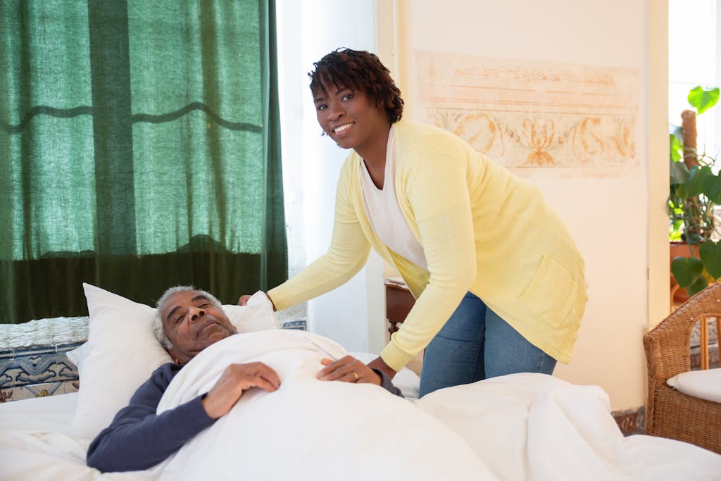 Woman Standing Beside Elderly Man on Bed